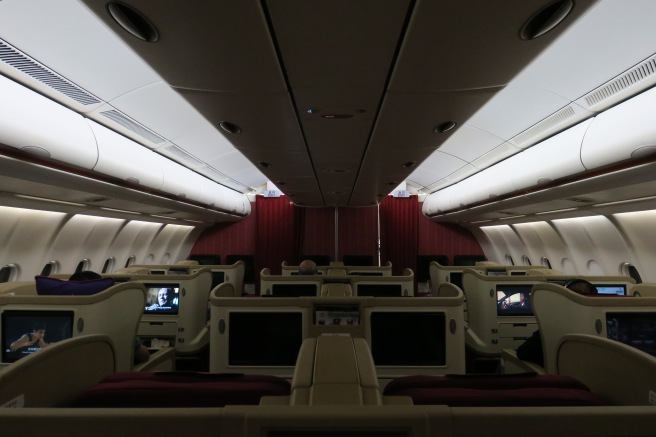 the inside of an airplane with seats and monitors