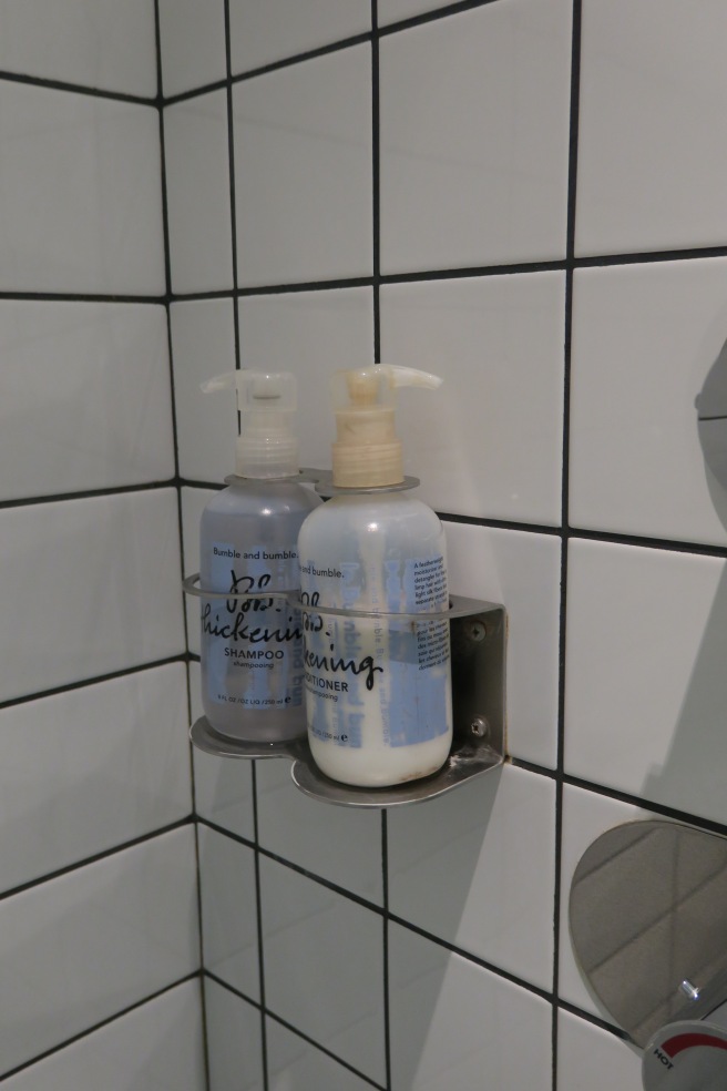 a couple of bottles of shampoo on a metal holder