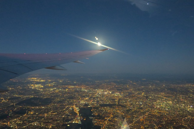 an airplane wing and city lights