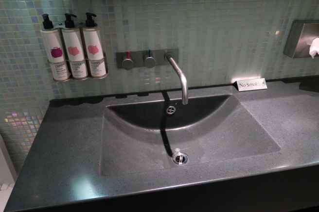 a sink with faucet and soap dispensers