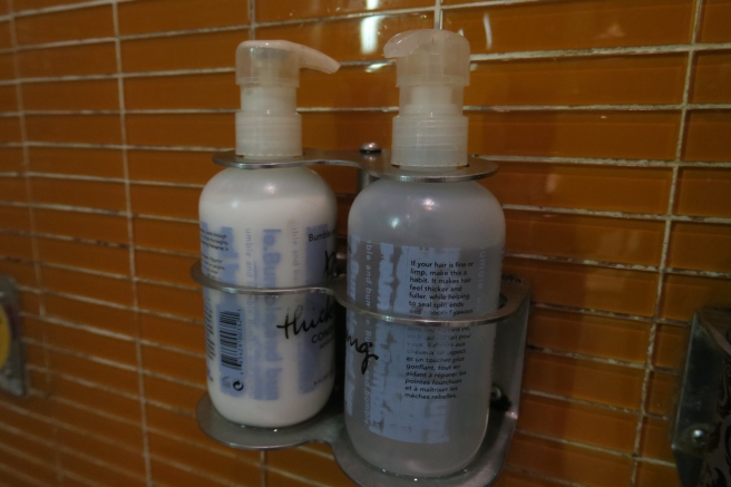 a couple of bottles of shampoo on a metal holder