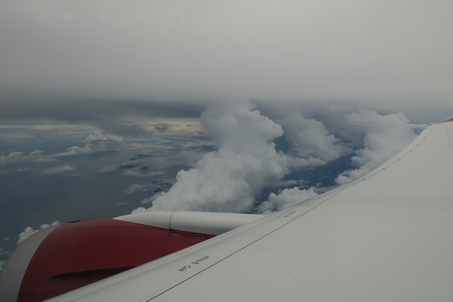a view of clouds and a plane wing