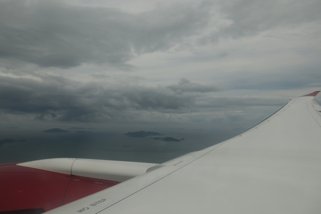 an airplane wing with clouds and water