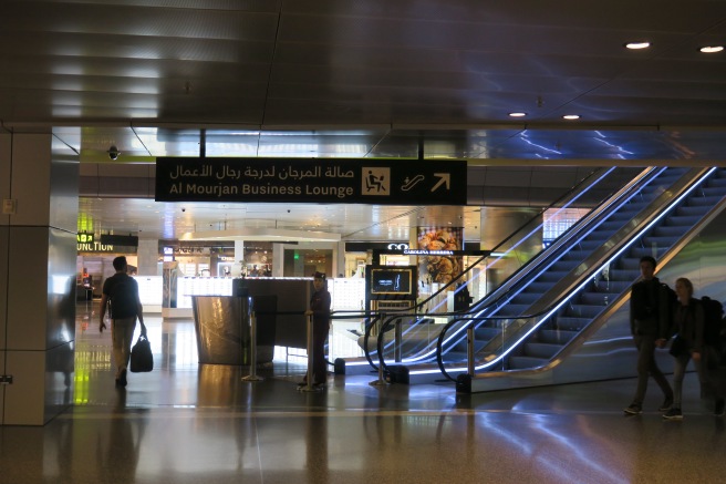 a man and woman standing in a building with escalators