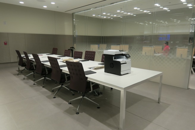 a large white table with chairs and a printer on it
