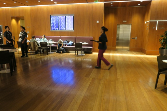 a woman walking in a room with a large screen