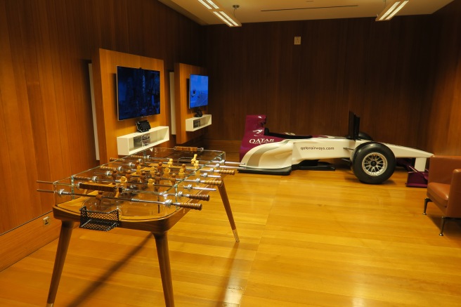 a game table in a room with tvs and a car