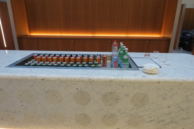 a row of soda cans and bottles on a counter