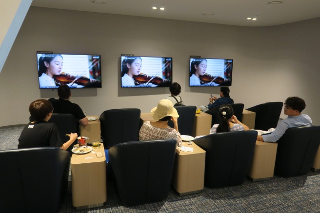 people sitting in chairs watching television