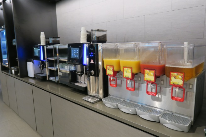 a group of juice dispensers on a counter