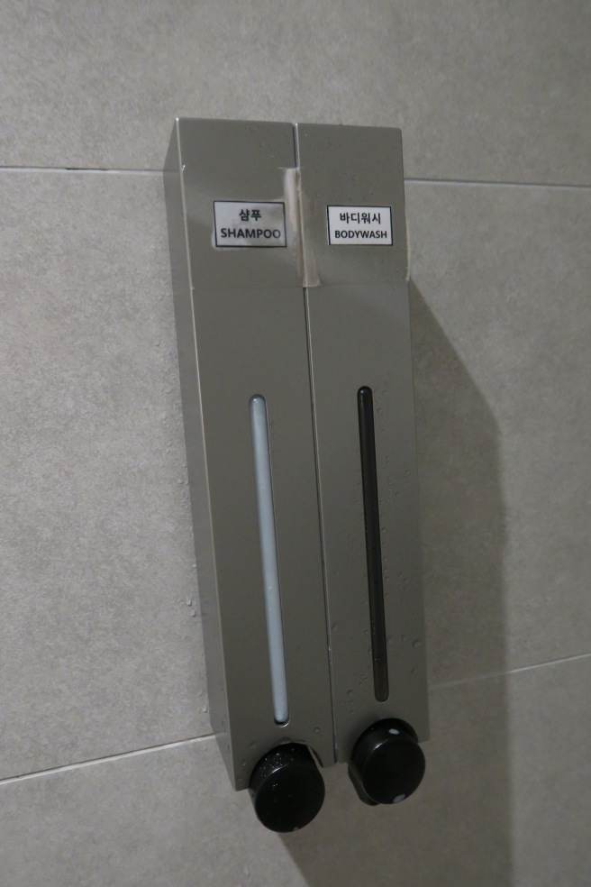 a soap dispenser on a tile wall