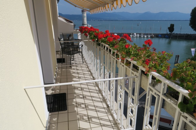 a balcony with red flowers on it