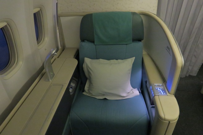 a seat with a pillow and a light blue pillow on it