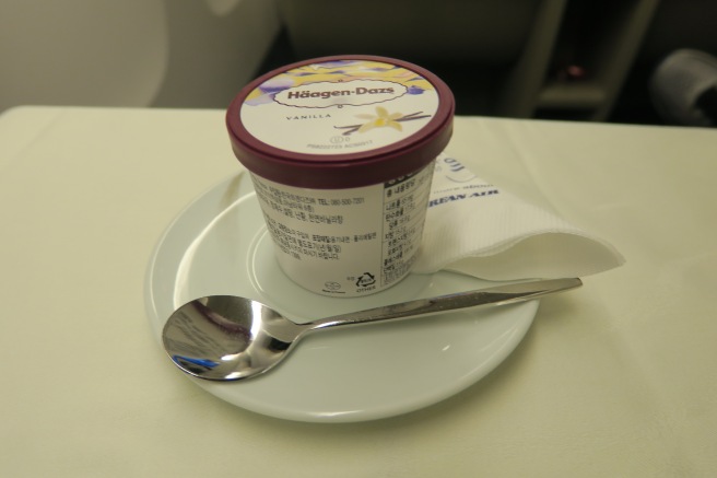a cup of ice cream on a plate with a spoon