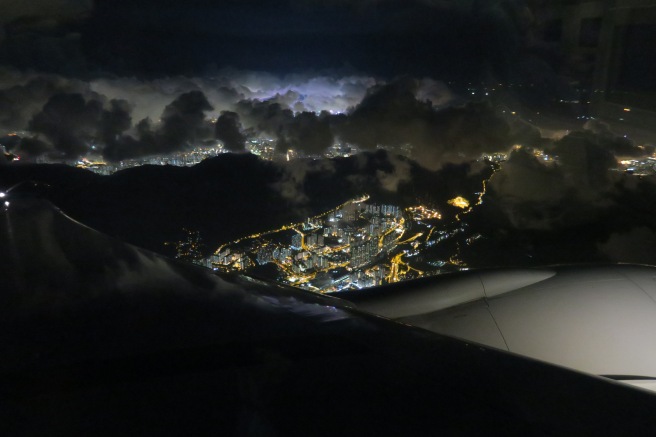 a city lights and clouds from an airplane