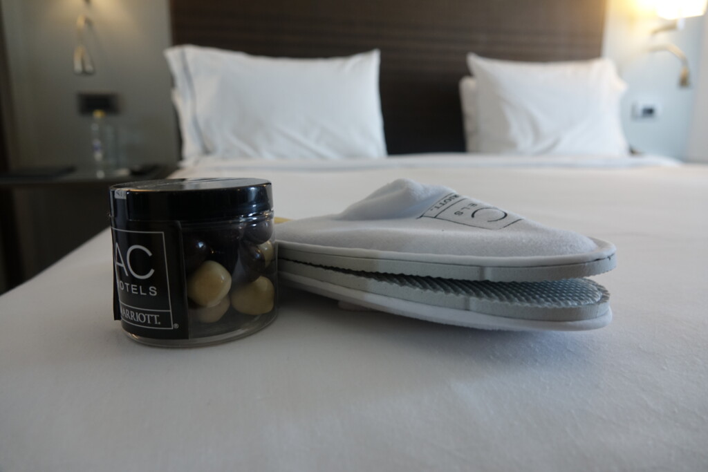 a pair of slippers and a jar of pebbles on a bed