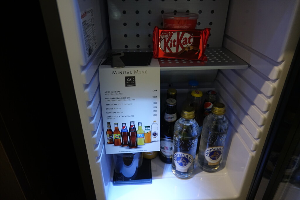 a small refrigerator with a small shelf full of drinks and candy