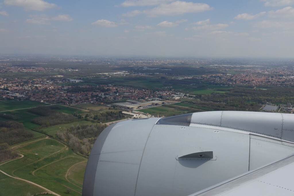 an airplane wing with a city in the background