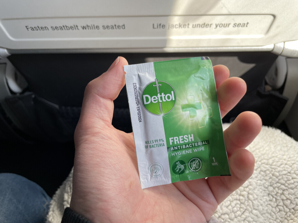 a hand holding a small packet of antibacterial wipes
