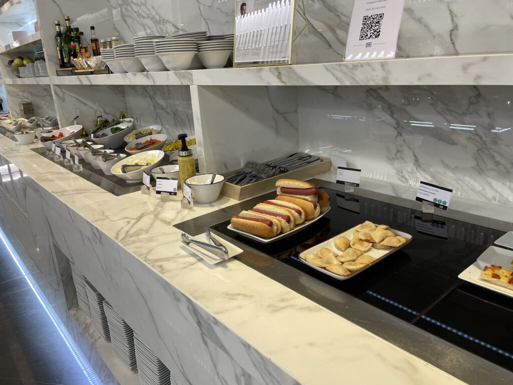 a buffet line with hot dogs and other food items