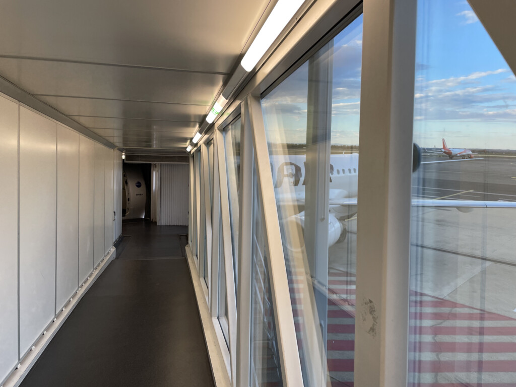 a hallway with windows and a plane in the background