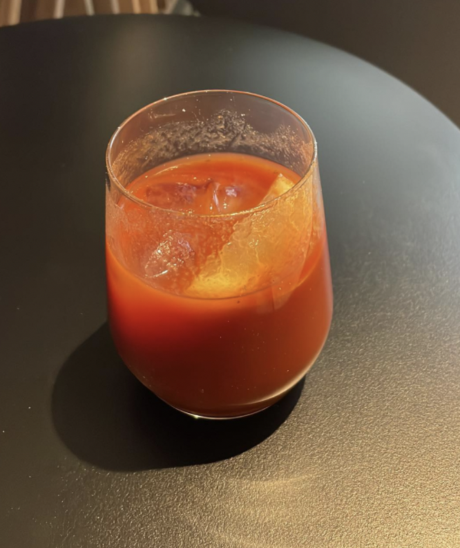 a glass of orange liquid with ice