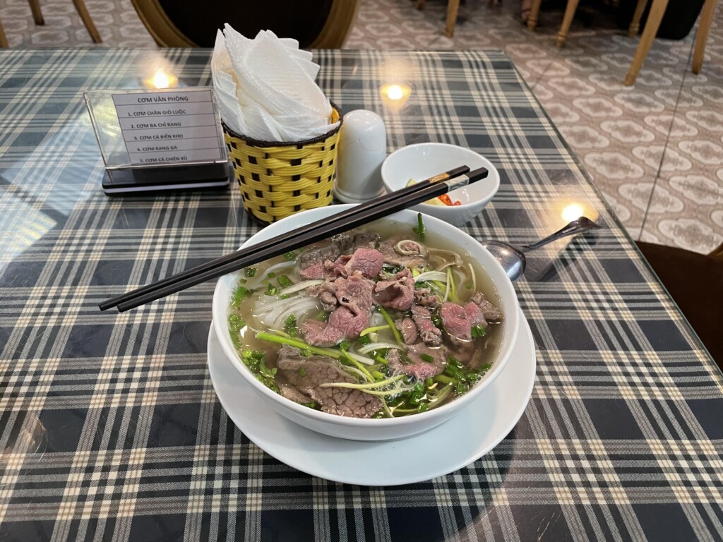 a bowl of soup with meat and vegetables on a table
