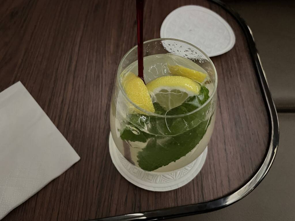 a glass of water with lemons and mint leaves
