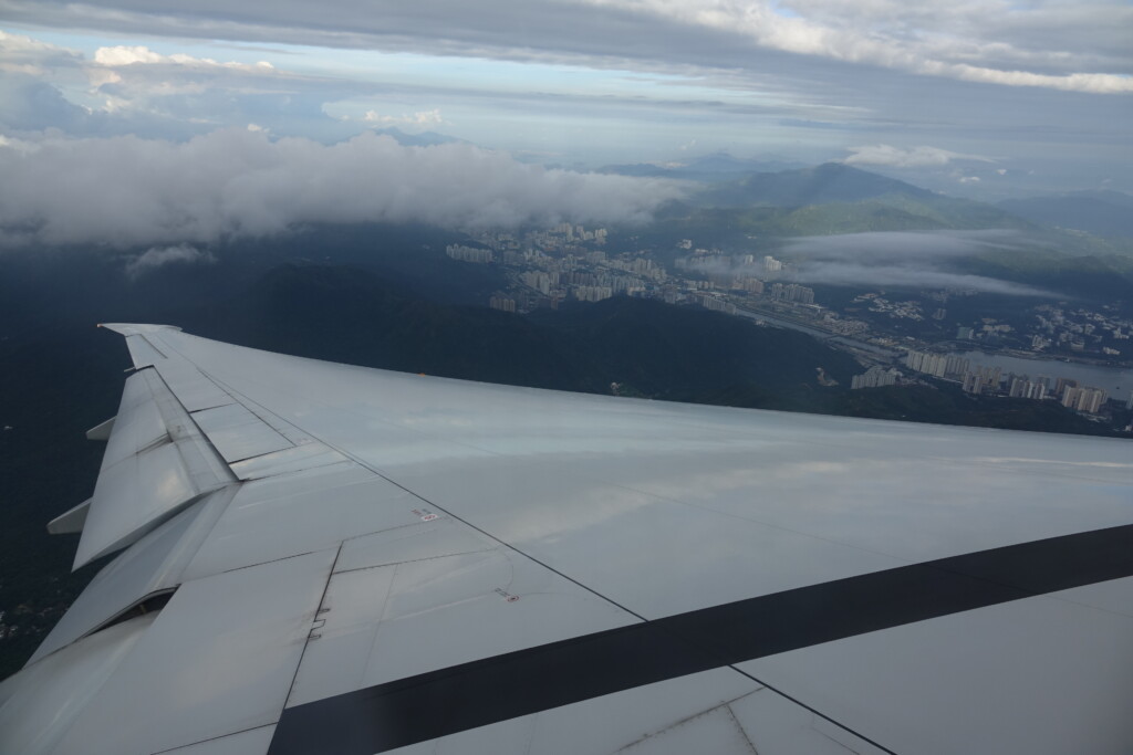 an airplane wing and city in the distance