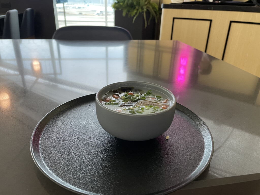 a bowl of soup on a round black plate