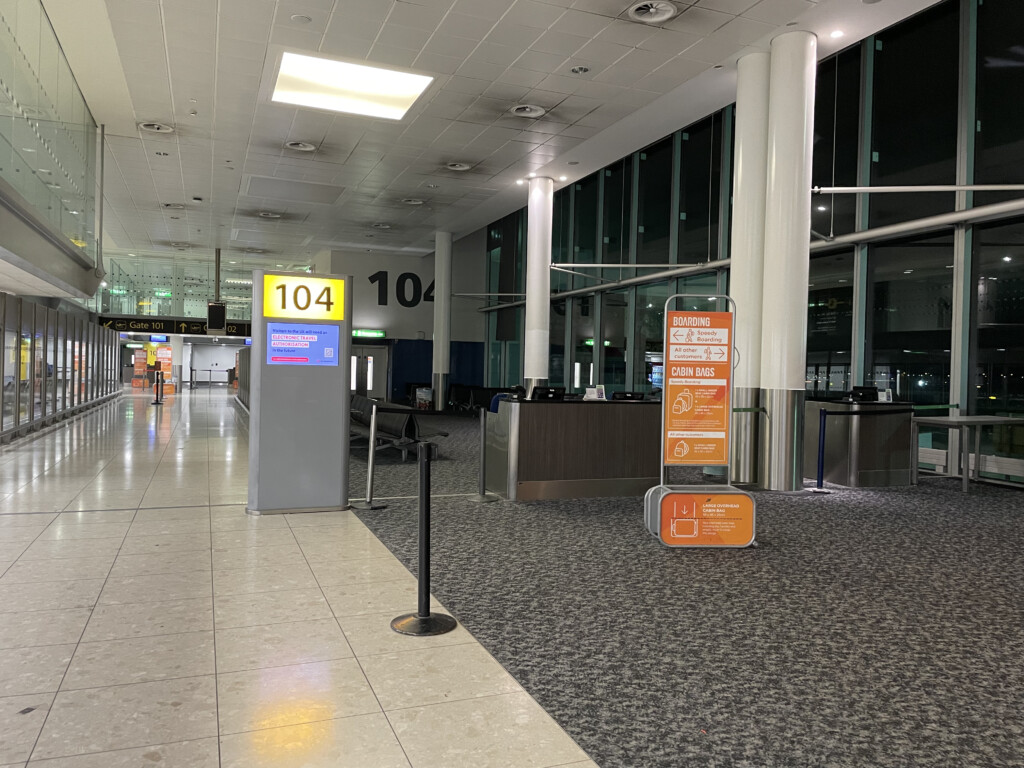 an airport terminal with signs and a counter