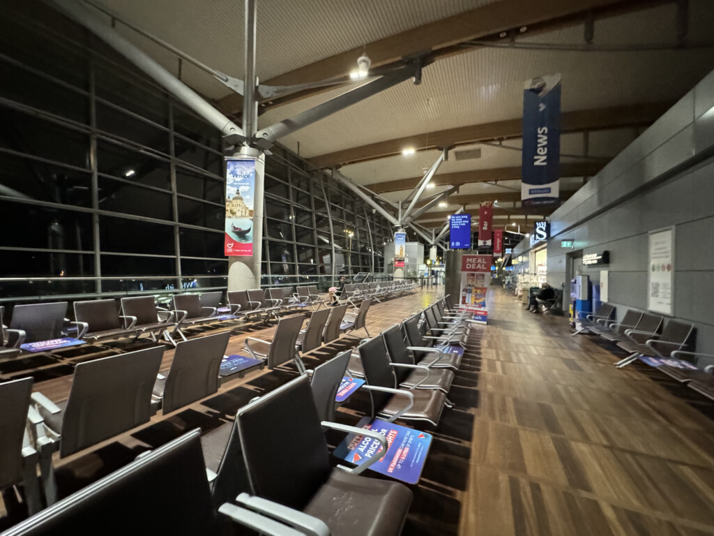 a large airport terminal with chairs and signs