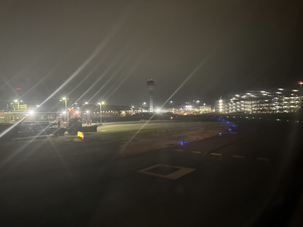 a runway at night with lights and a tower
