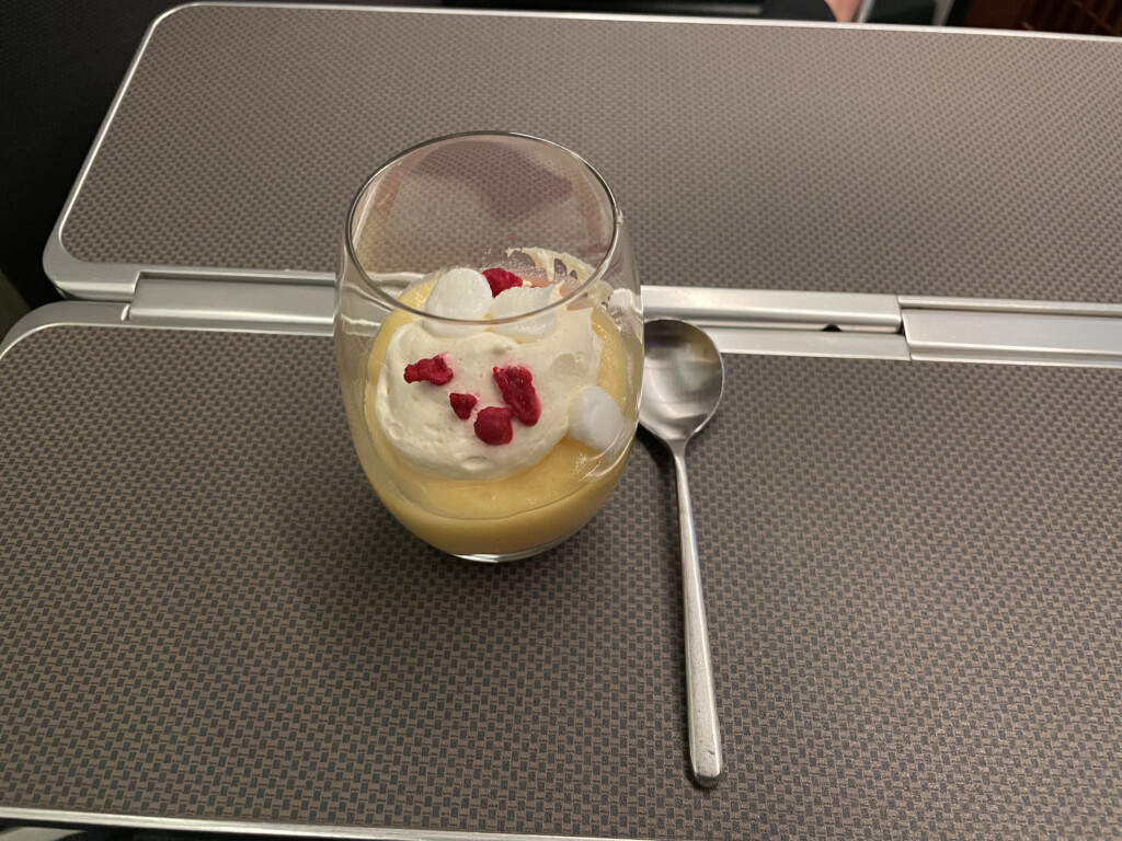 a glass of pudding with whipped cream and red berries