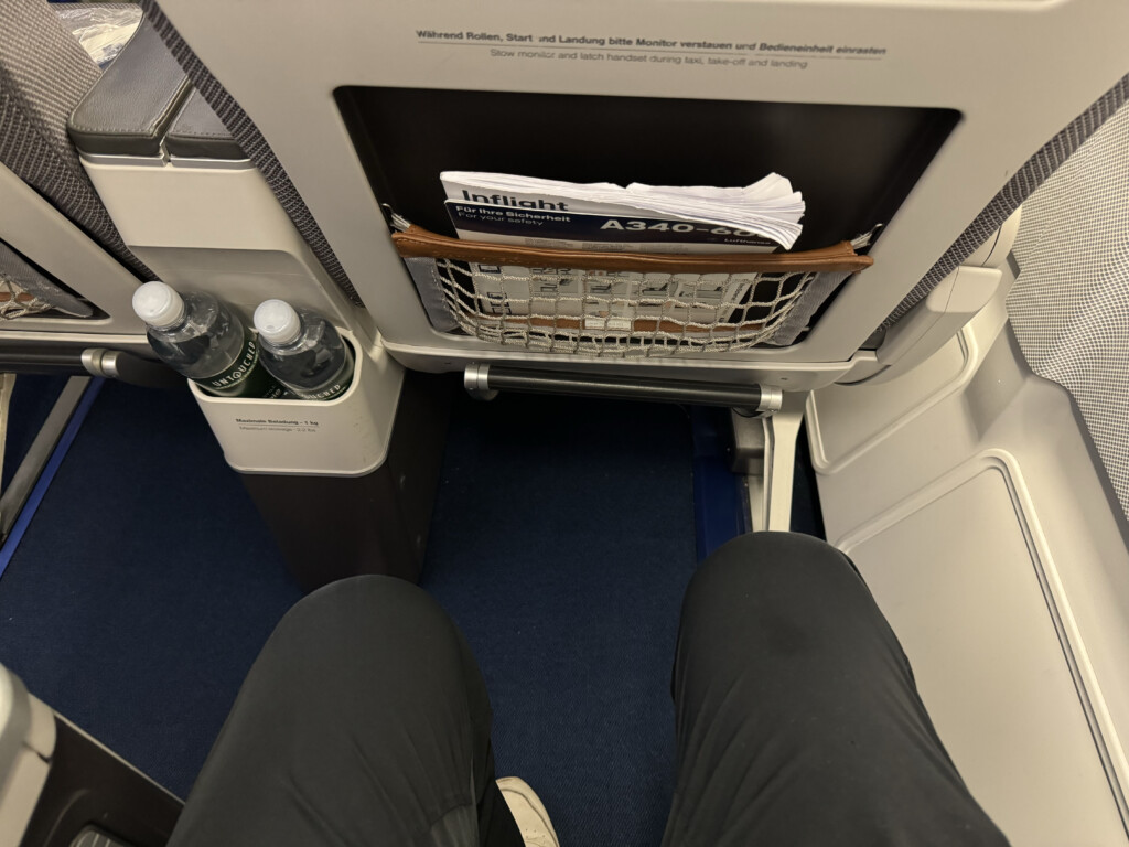 a person's legs in a basket on an airplane