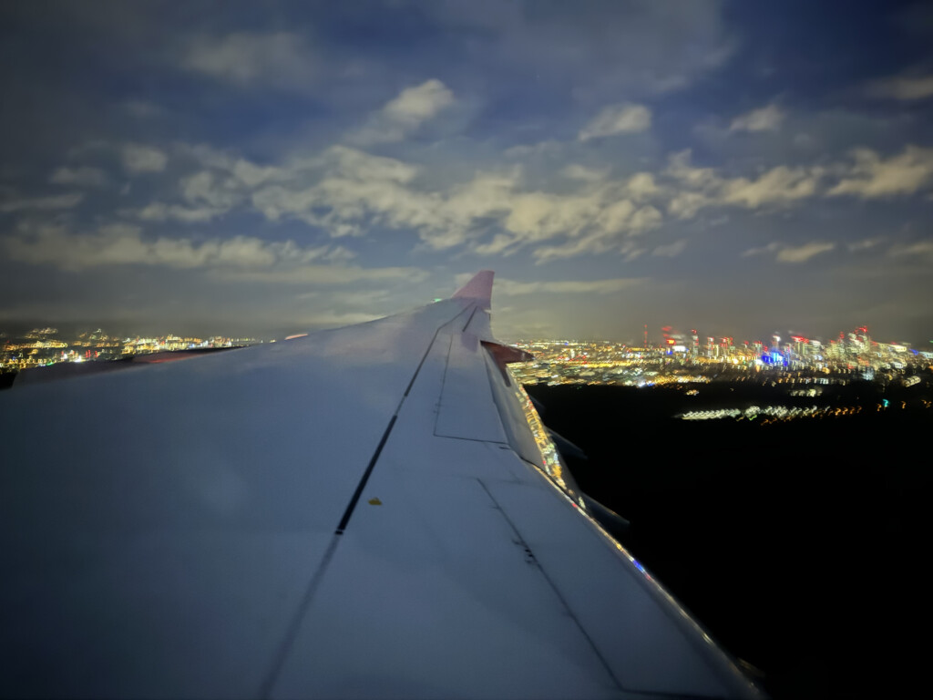an airplane wing with lights in the sky