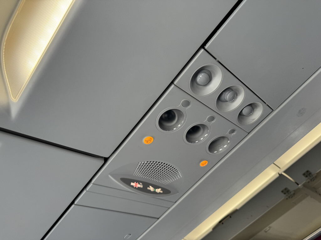 a grey panel with speakers and a speaker on the ceiling