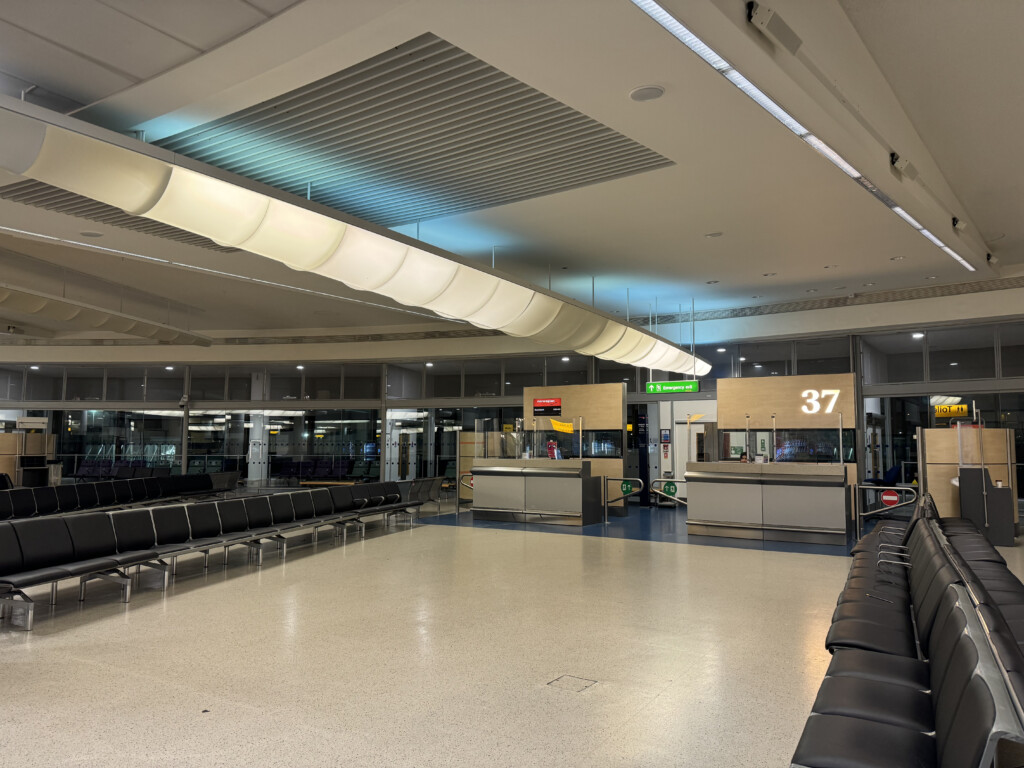 a large airport terminal with chairs and a counter