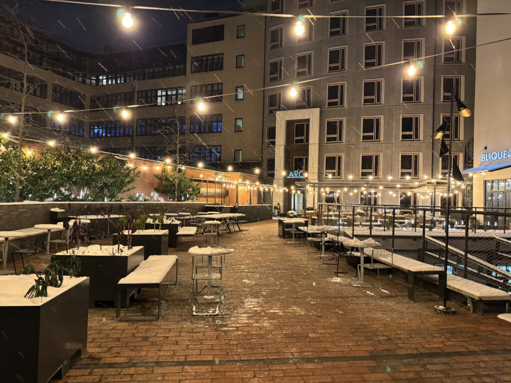 a courtyard with tables and chairs and lights