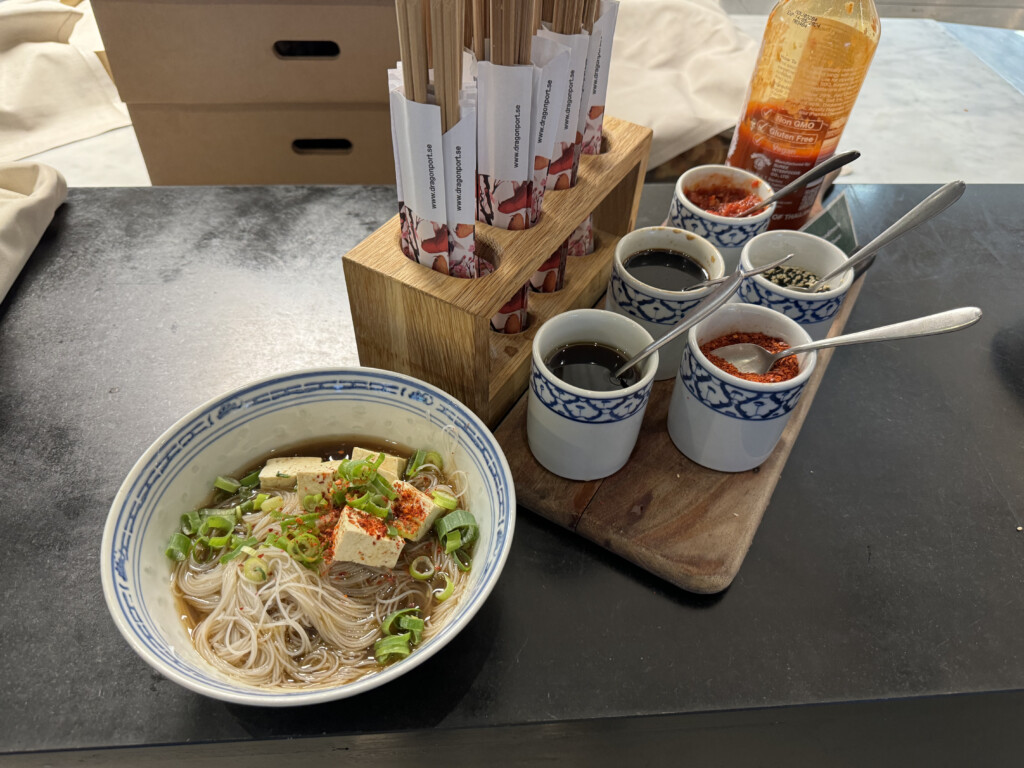 a bowl of noodles and sauces on a table