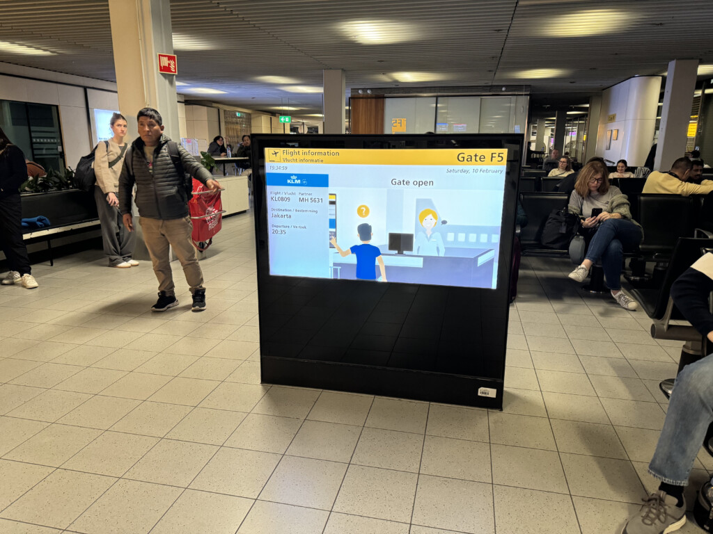 a large screen in a room with people in the background