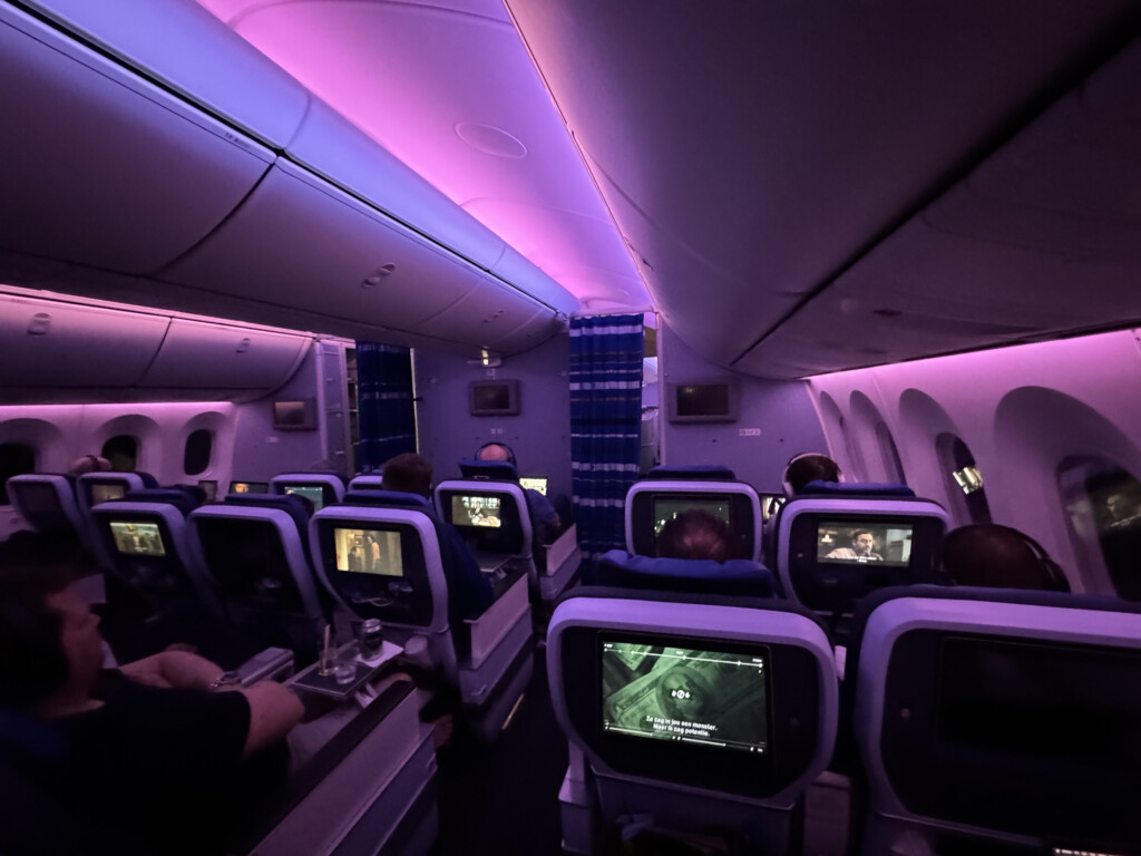 a row of seats with monitors on the back of a plane