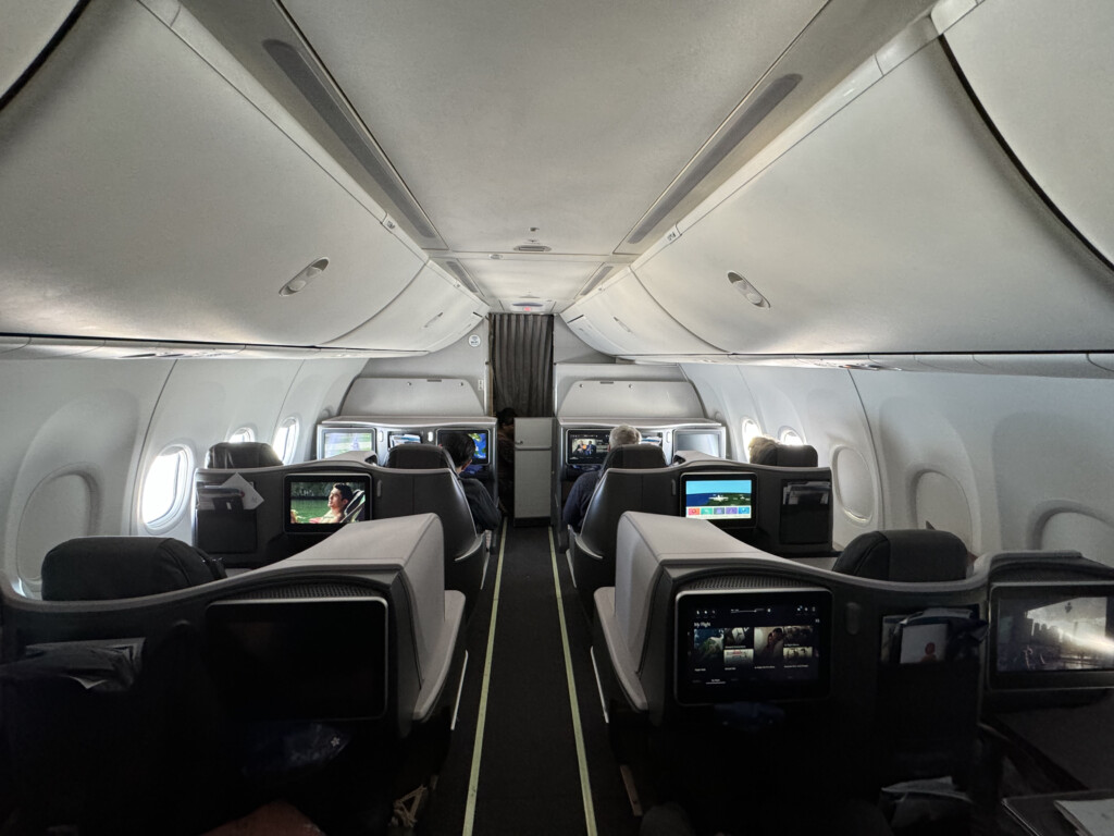 inside an airplane with seats and monitors