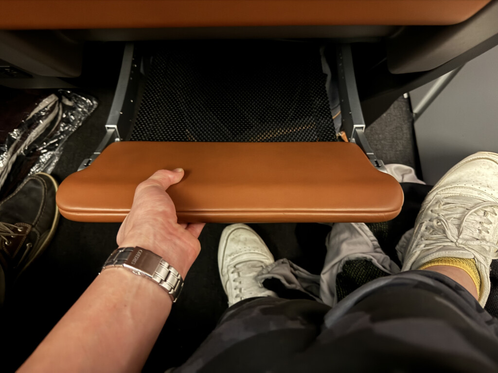 a person holding a brown leather arm rest