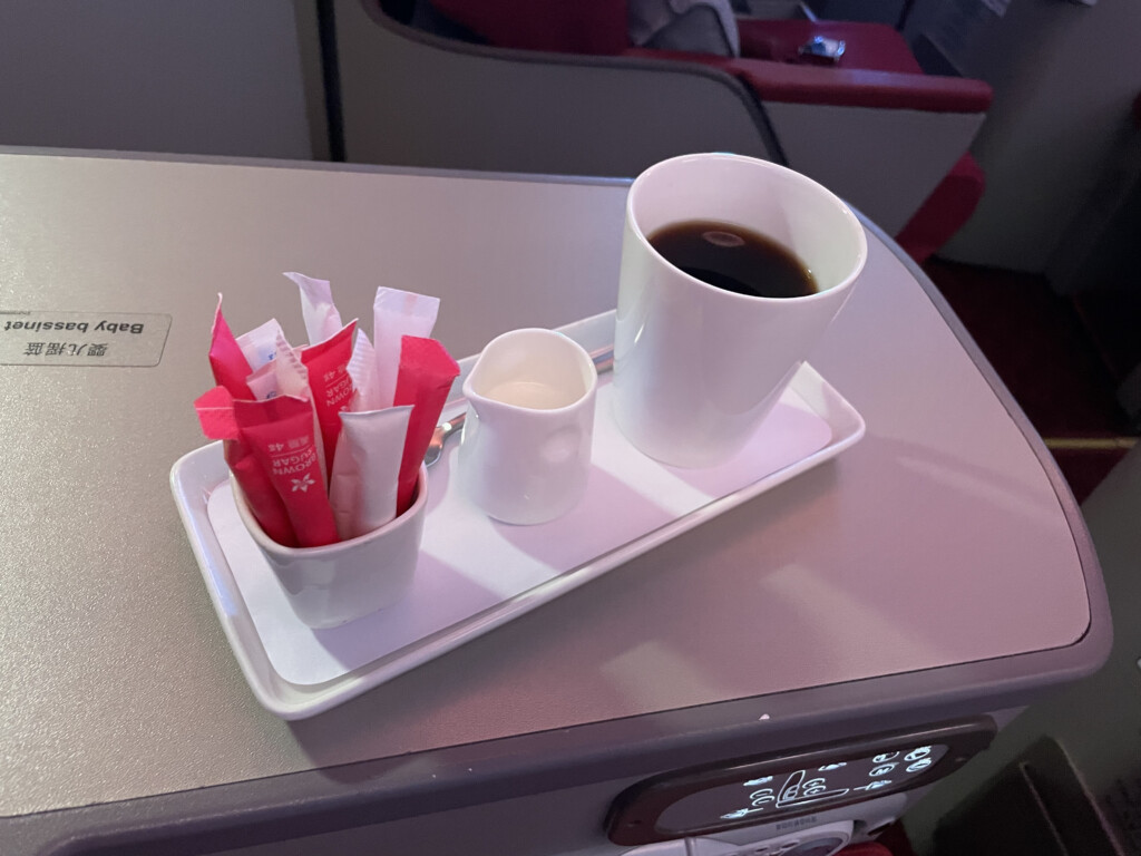 a tray with a cup of coffee and sugar packets on it