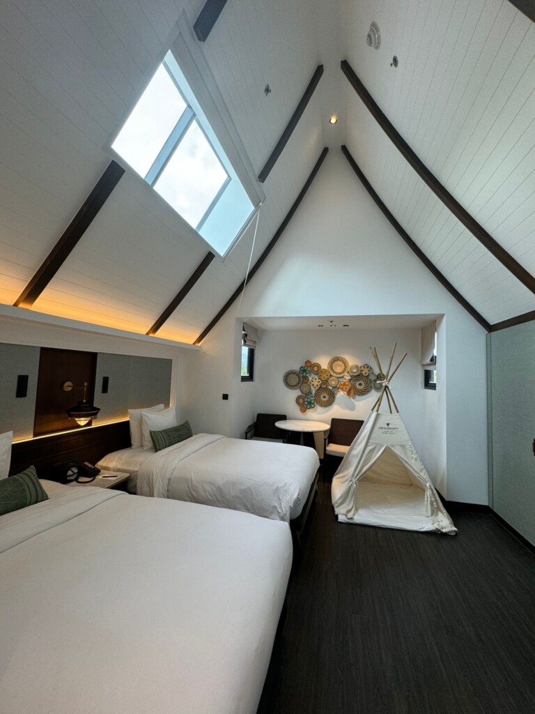 a room with two beds and a tent