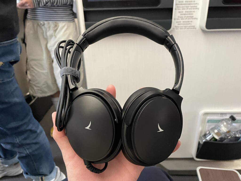 a hand holding a pair of headphones