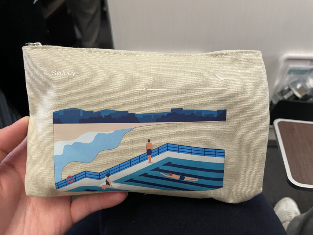 a hand holding a small bag with a picture of a beach and a swimming pool