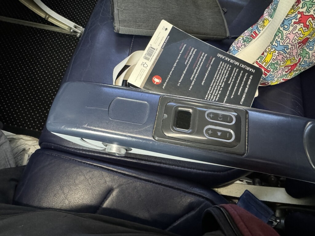 a book and remote control on a seat