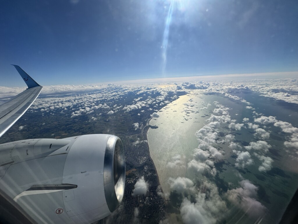 an airplane wing and engine above clouds